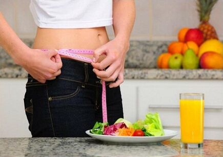 Une fille qui perd du poids pendant un régime mesure son tour de taille
